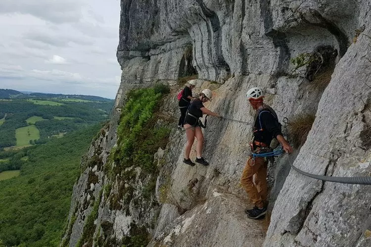trois alpinistes font de l'escalade sur une paroi rocheuse des falaises qui dominent saint antonin noble val