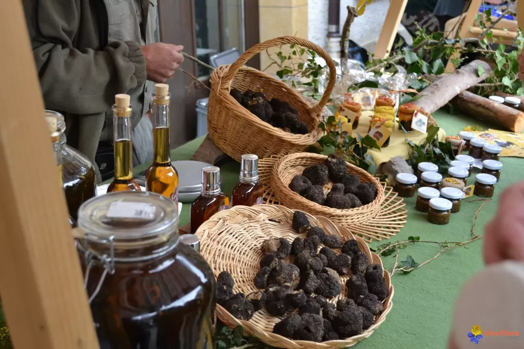 sur un marché, un vendeur a posé sur son étal quelques paniers de truffes fraîches, mais aussi des bocaux de truffes en conserve, des boutelles d'huile parfumée à la truffe et différents autres produits fins