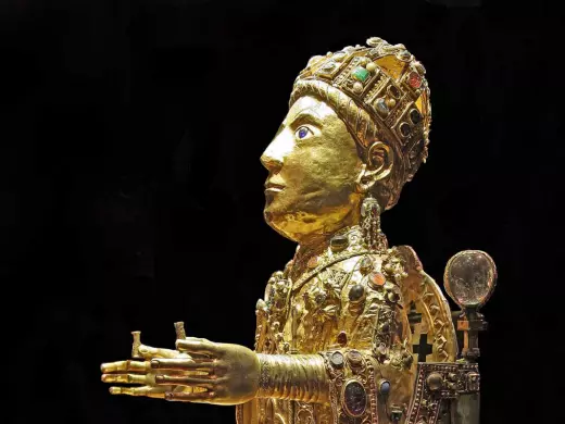 statue de sainte foy, trésor de conques en aveyron ; la statue est en or, avec des pierres précieuses, dans une attitude d'offrande