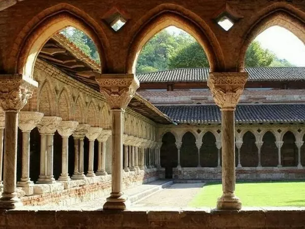 le cloitre  de l'abbaye de moissac dans le tarn et garonne, région occitanie ; on aperçoit trois chapiteaux et arcades en ogives au premier plan et sur le côté gauche de la photo et dans le fond les rangées de chapiteaux et arcades.
