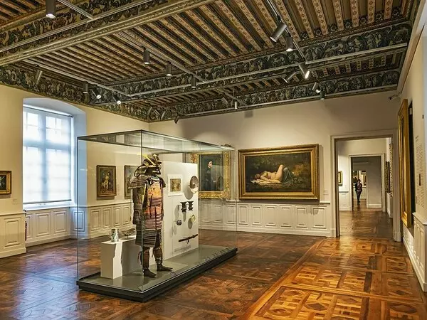 une salle du musée ingres bourdelle de montauban ; le plafond est de style renaissance, à caisson ; différentes peintures accrochées au mur ; une armure de samouraï dans une vitrine au centre de la photo