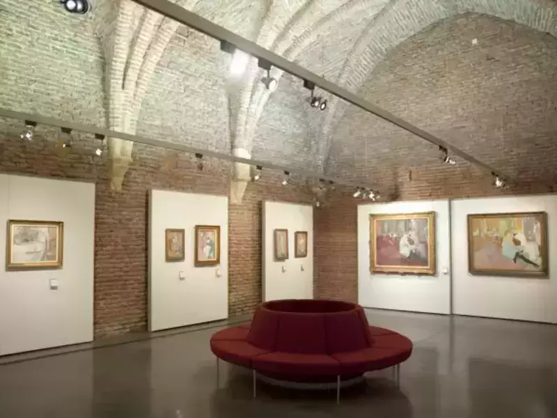 salle voûtée en briques apparentes du musée toulouse lautrec à albi, avec différentes peinture accrochées au mur